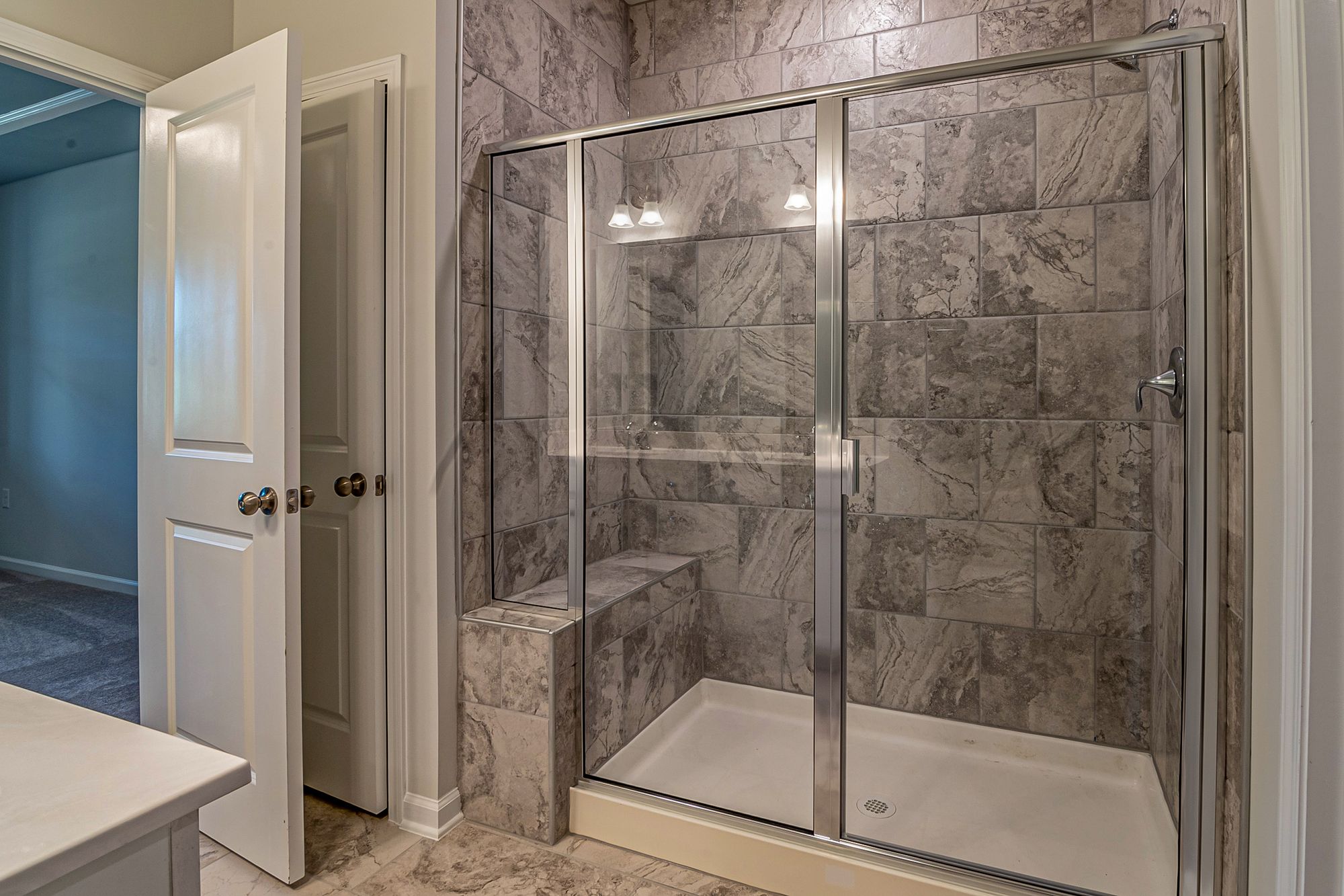 A walk-in shower with a shower pan.