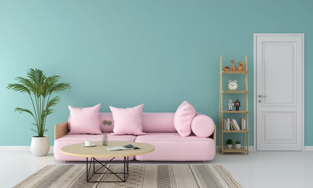 A living room with a pink sofa, a plant, a table, and a wooden shelf.