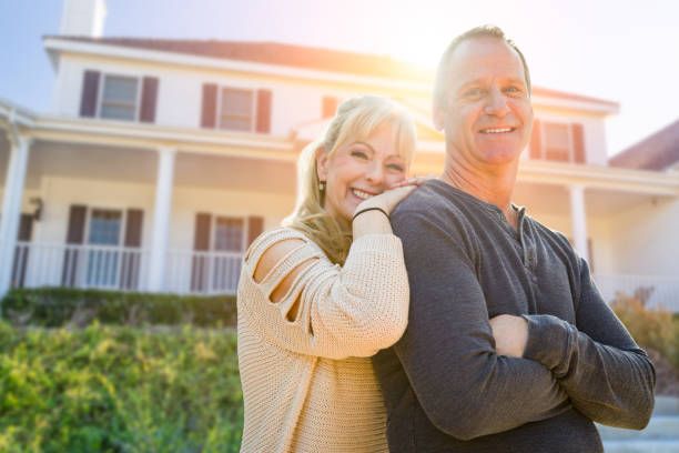 An old couple in front of their house.