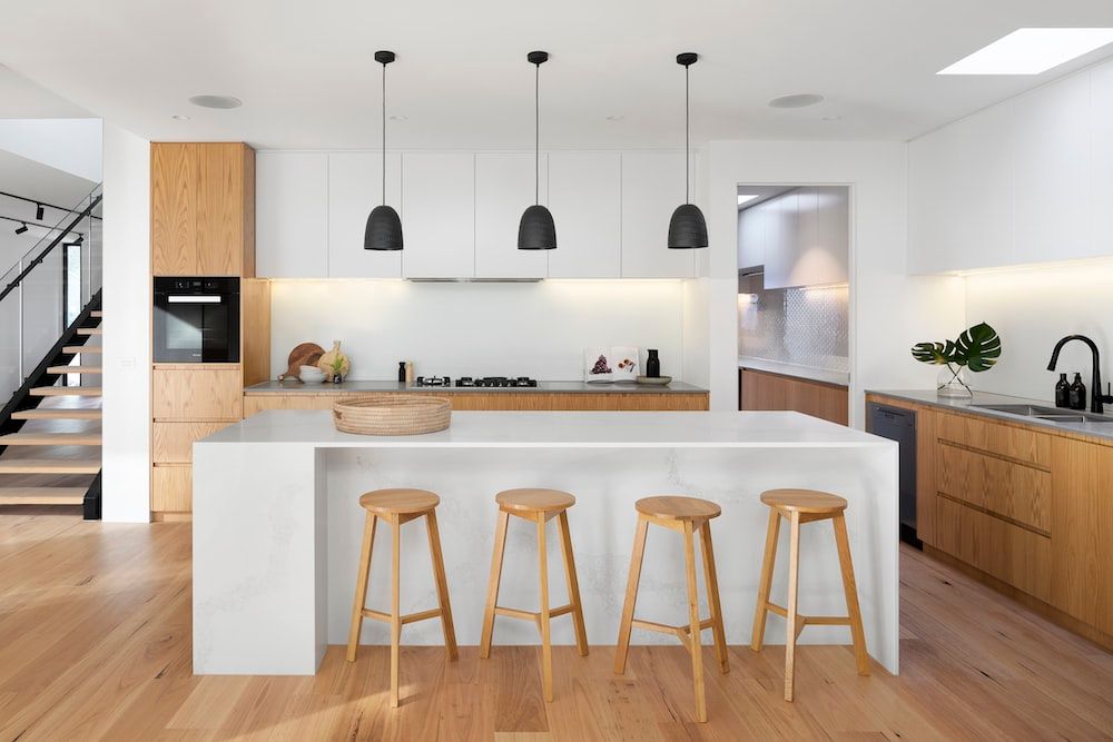 A white kitchen island with wooden stools.