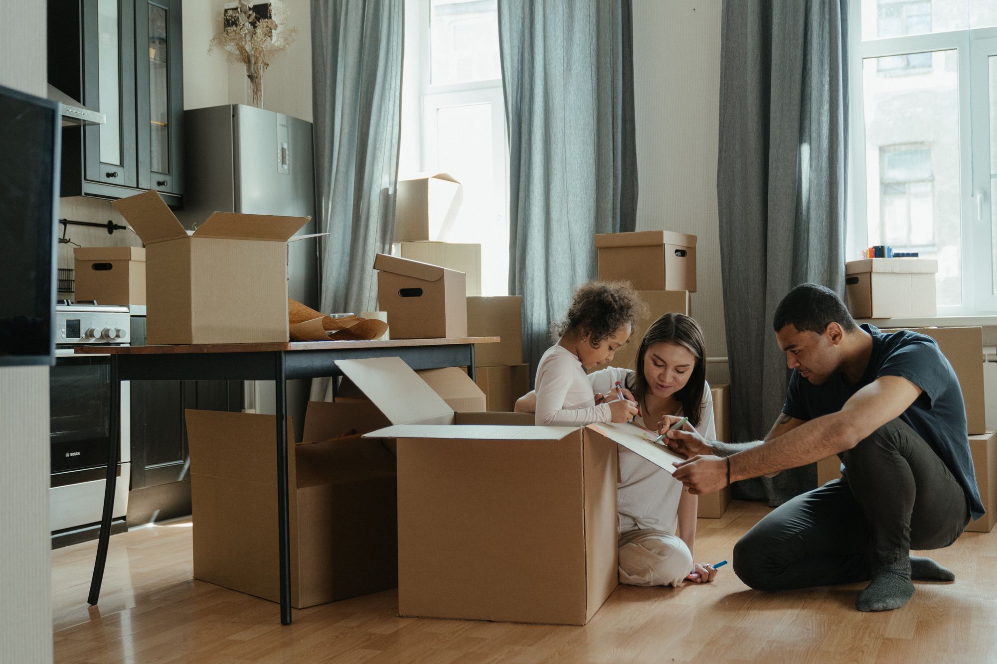 A family with boxes around as they move into a new house.