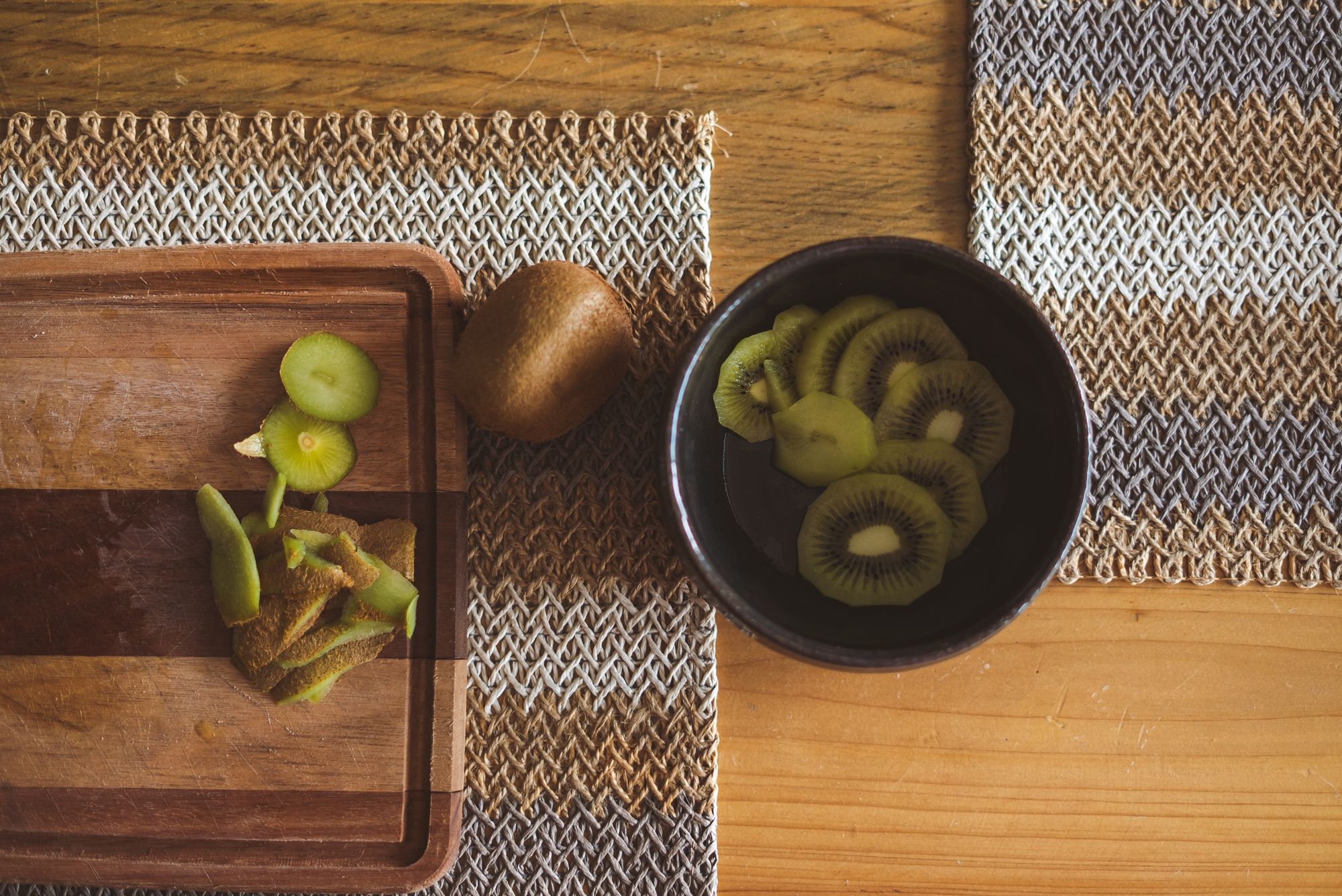 Two placemats on top of a wooden table.