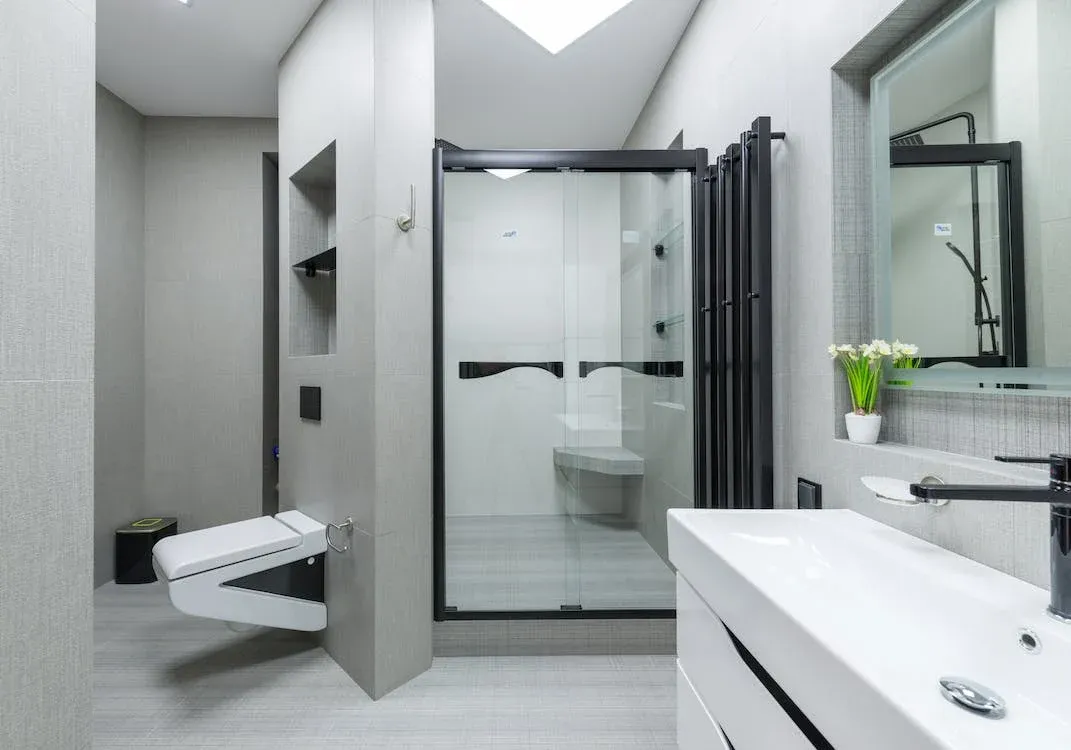 A bathroom with shower enclosure and bench.