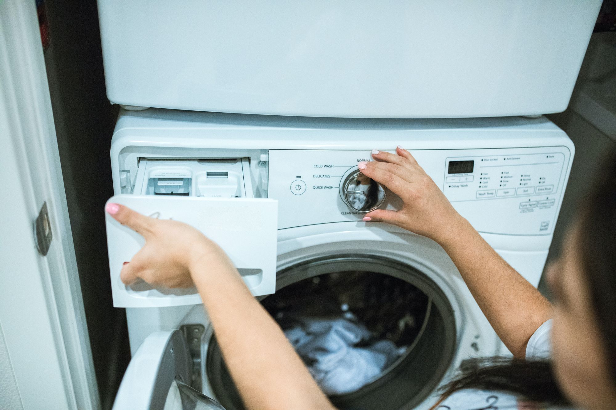 A woman operating a washing machine.