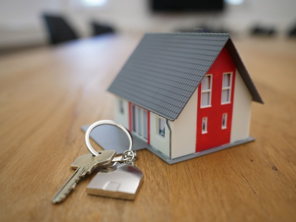 A miniature house with a home key.