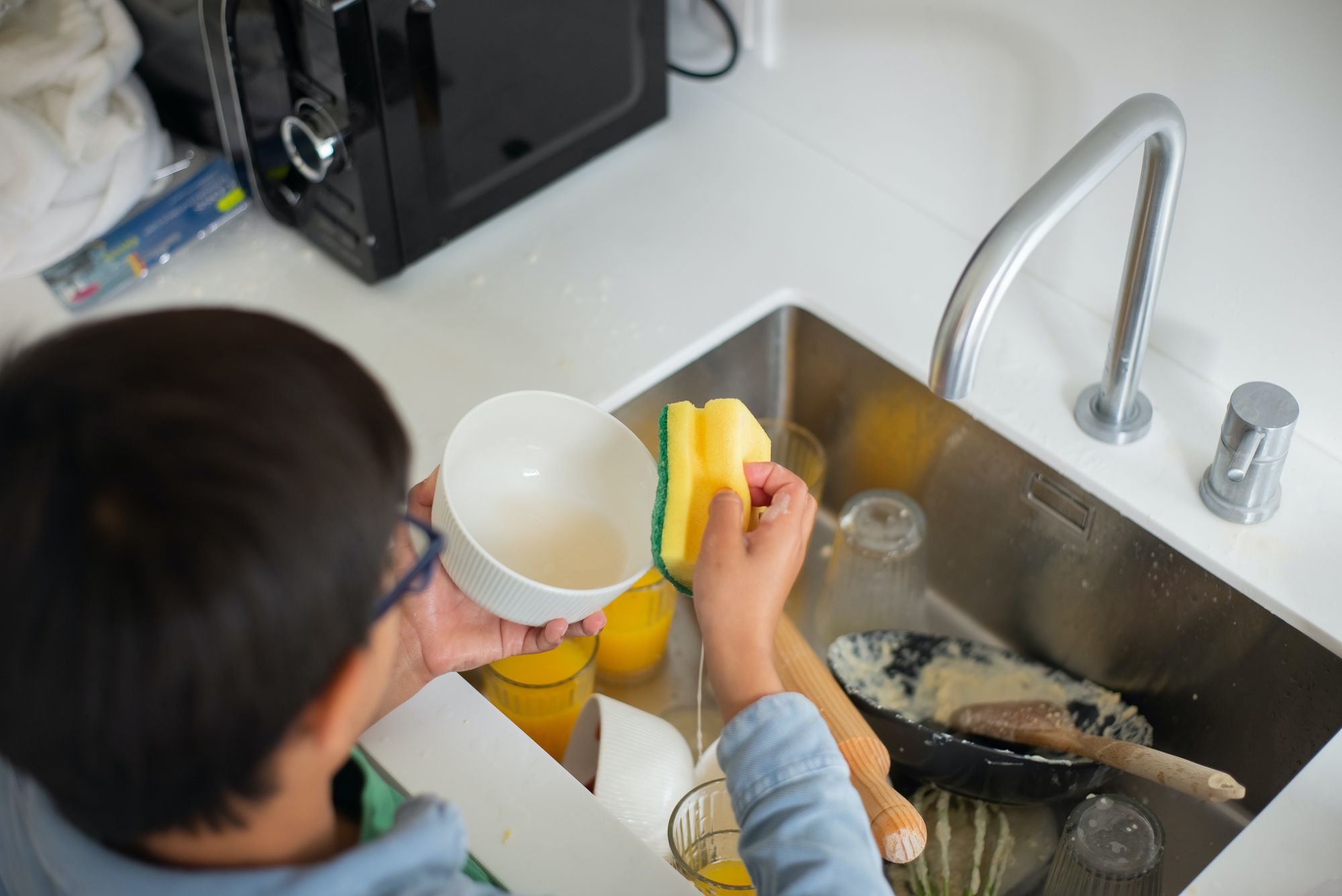 A man doing the dishes at a kitchen sink.