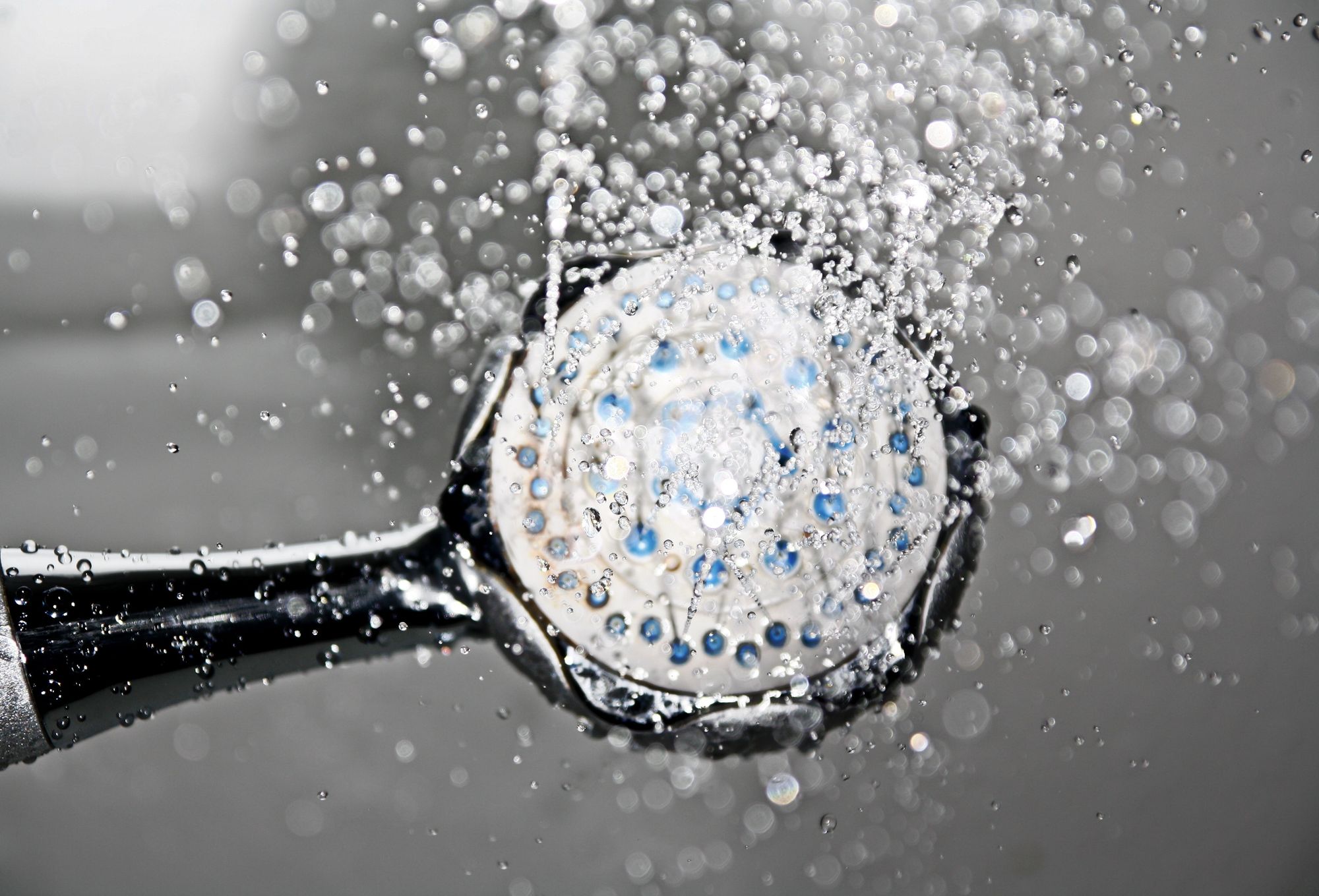 A shower head with running water.